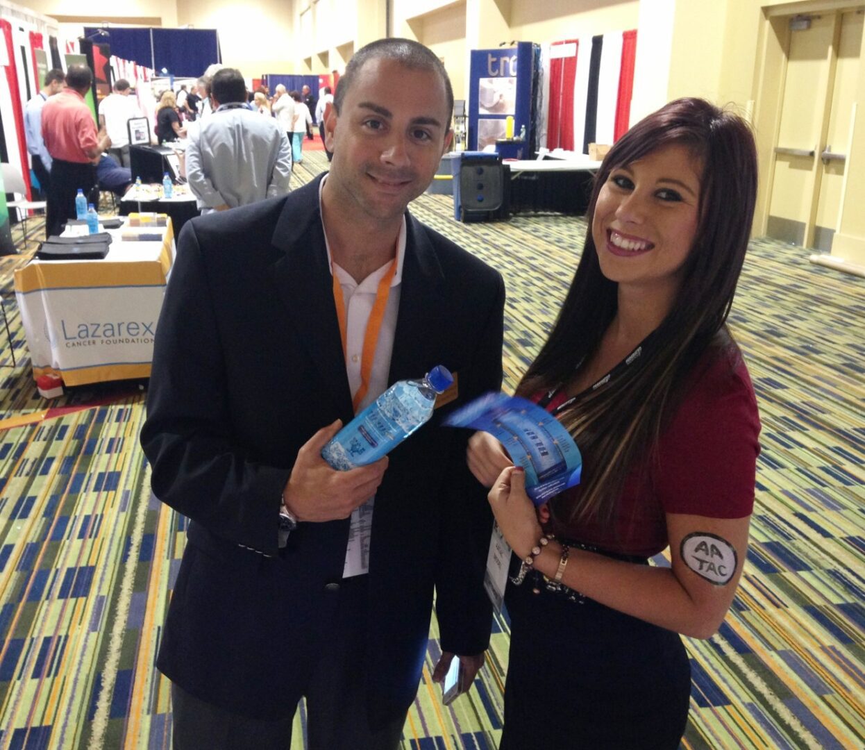 Two people holding water bottles in a room.